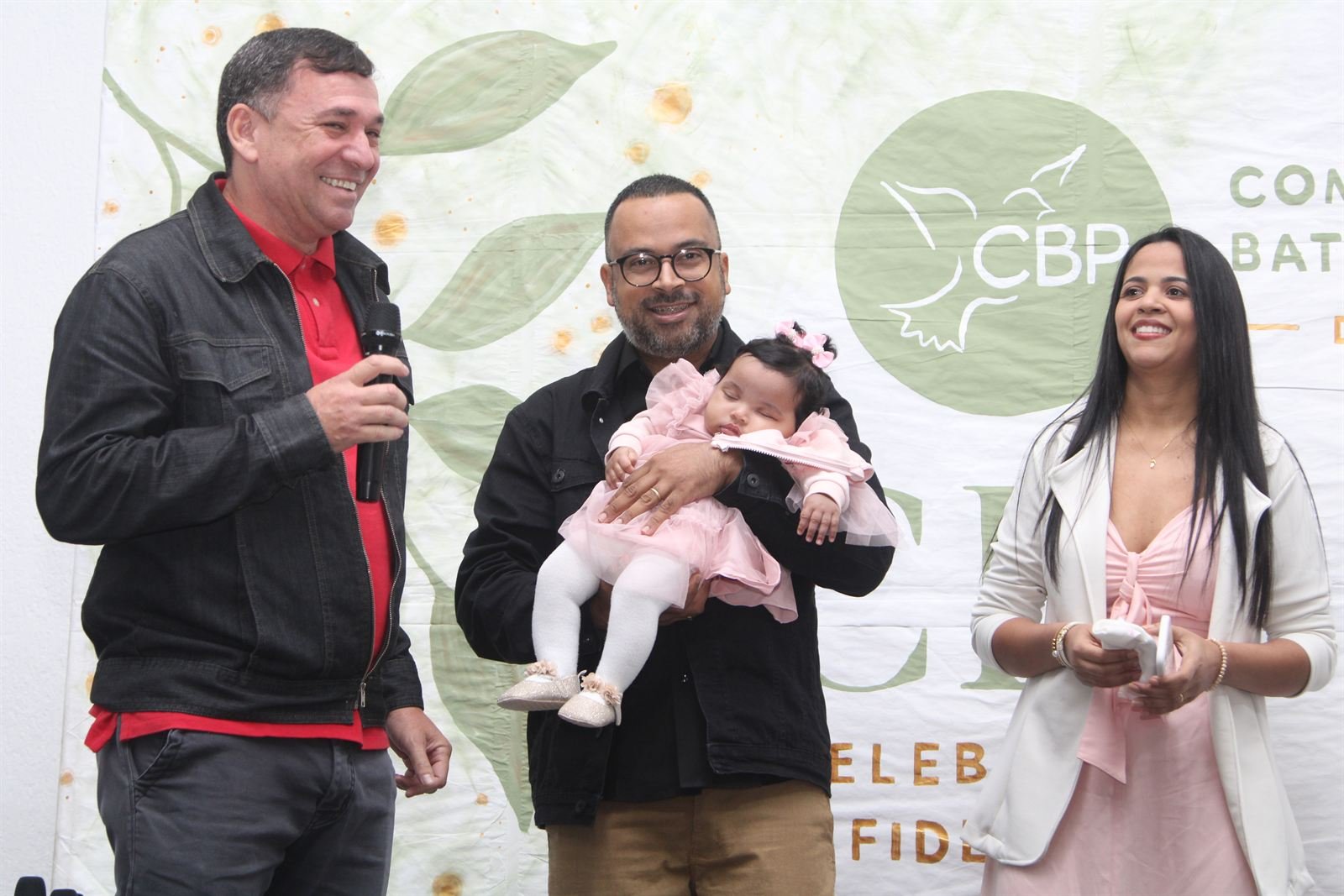 Família com a bebê no altar durante o culto
